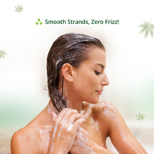Woman washing her hair with a Hemp product labeled 'Smooth Strands, Zero Frizz!' on a white background.