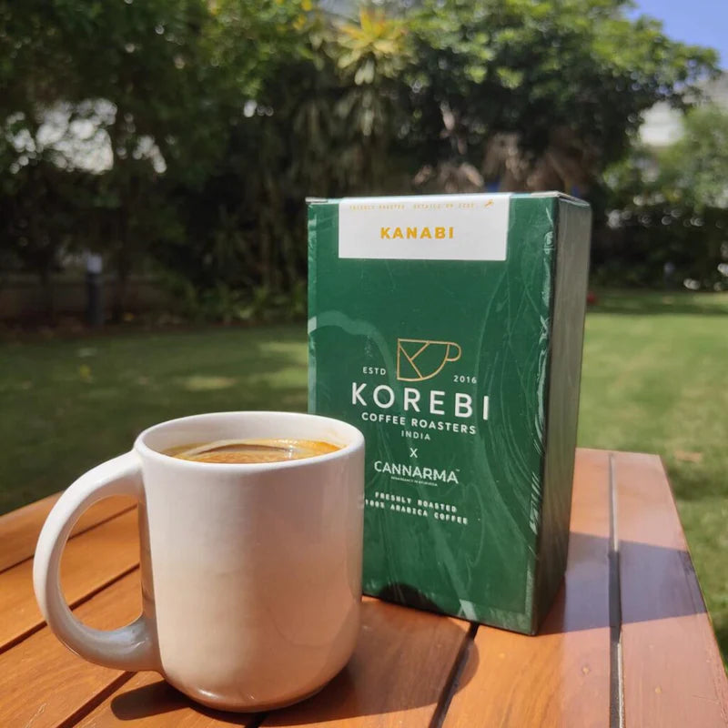 White coffee mug and green korebi hemp coffee box on a wooden table in a garden.