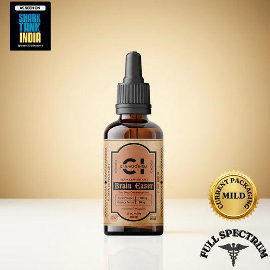 Bottle of Cannazo 'Brain Easer CBD Drops' with a gold label on a beige background, featuring Shark Tank India branding.leep