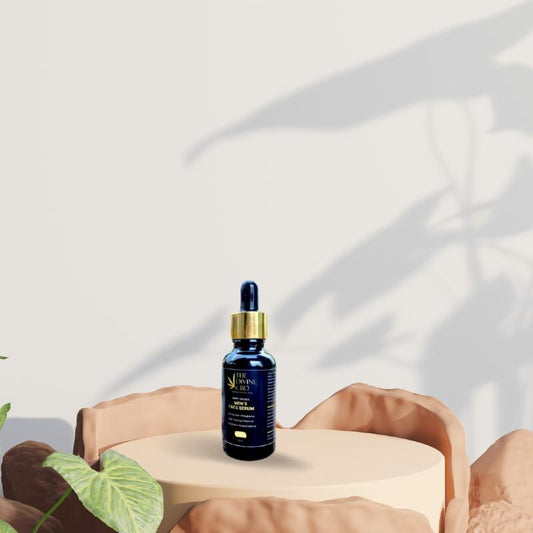 Blue glass bottle of face serum with a dropper on a beige podium, surrounded by natural elements and leaf shadows.
