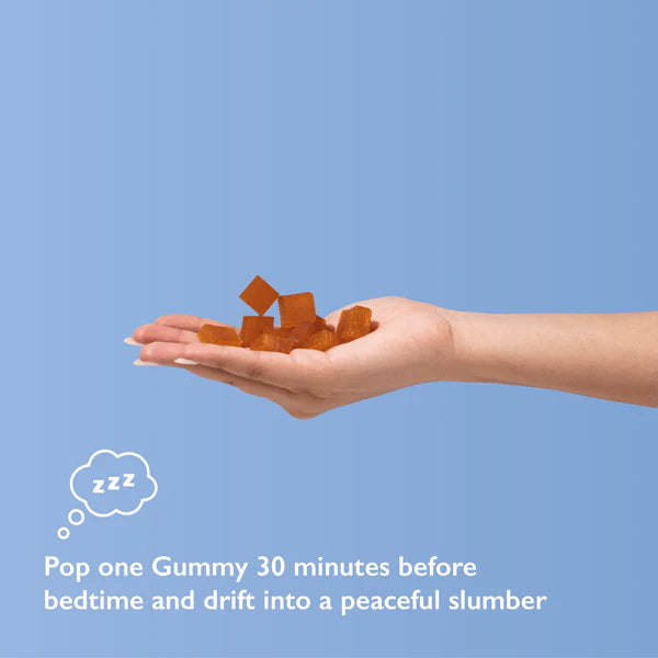 A hand holding orange-brown gummies on a light blue background.