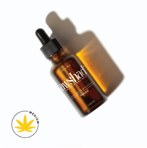 Amber glass dropper bottle of CBD oil with shadow, labeled 