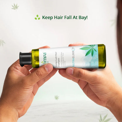 Person holding a bottle of hemp-based shampoo with a visible brand label on a light background.