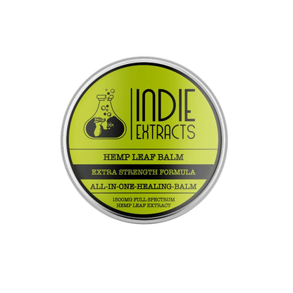Circular label of "Indie Extracts All in One Hemp Leaf CBD Balm" on a metal container with a lime green background and black text and graphics.