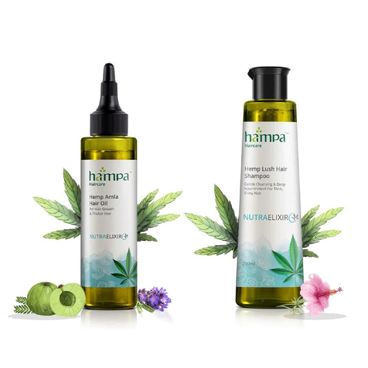 Two bottles of hampa Hemp hair care products with leaves and flowers on a white background