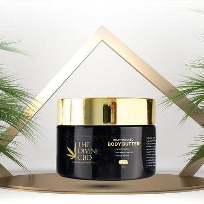 Black jar of "The Divine CBD" hemp-infused body butter with a gold lid, surrounded by golden lines and palm leaves.