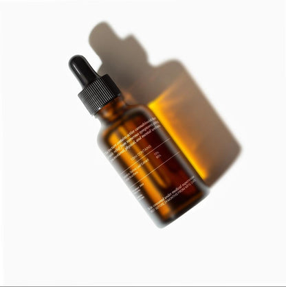 Amber glass CBD Oil dropper bottle on white background with distinct shadow.