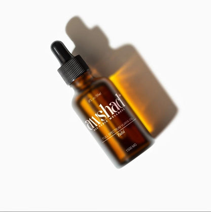 Amber glass awshad CBD Oil bottle with label on a white background, casting a shadow.
