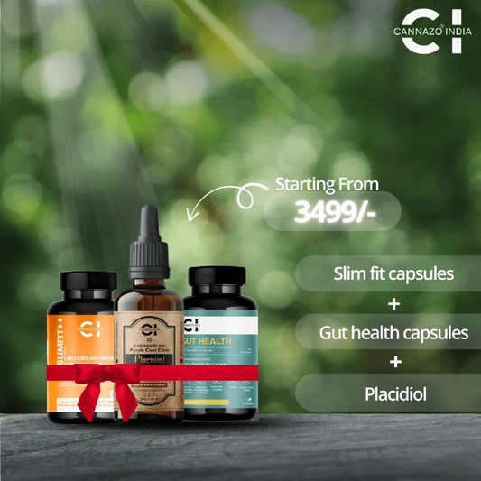 Three CBD product bottles with a red ribbon on a wooden surface, blurred green background, Cannazo India branding.
