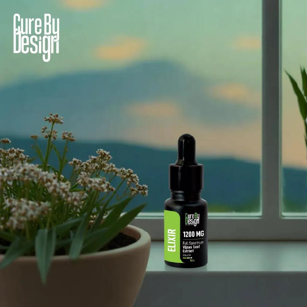 Bottle of 'Cure By Design' CBD Oil elixir with dropper on a windowsill with a scenic view.
