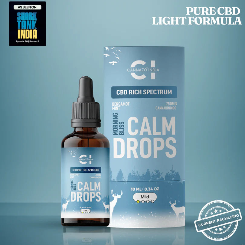 CBD Rich Calm Drops in an amber glass dropper bottle next to its light blue packaging box, featuring a light blue background with Shark Tank India promotional badges.