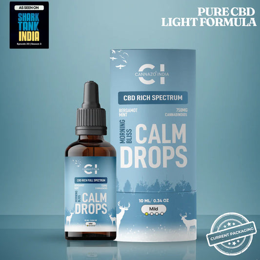 CBD Rich Calm Drops in an amber glass dropper bottle next to its light blue packaging box, featuring a light blue background with Shark Tank India promotional badges.