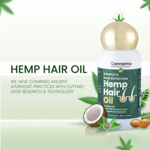 Load image into Gallery viewer, A bottle of Cannarma Hemp Hair Oil with natural ingredients like a halved coconut, almond nuts, and green leaves around it.
