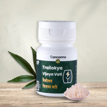 Load image into Gallery viewer, White bottle with &quot;Trailokya Vijaya Vati&quot; label, cannabis leaves to the left, and a bowl of pink crystals to the right.
