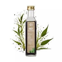 Load image into Gallery viewer, A bottle of cannazo hemp seed oil with plant leaves and splashes around it, against a white background.
