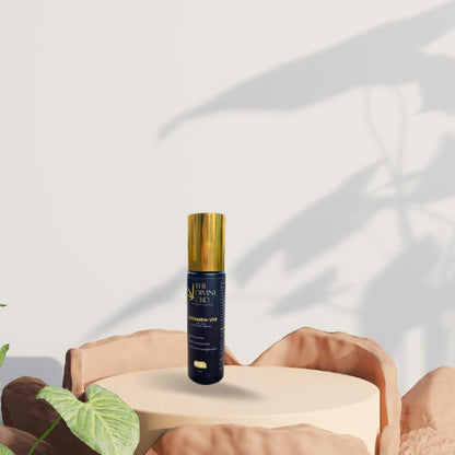 Paarmi Cares "THE DIVINE CBD CATALYZER-V10" bottle on a round pedestal with plant shadows in the background.