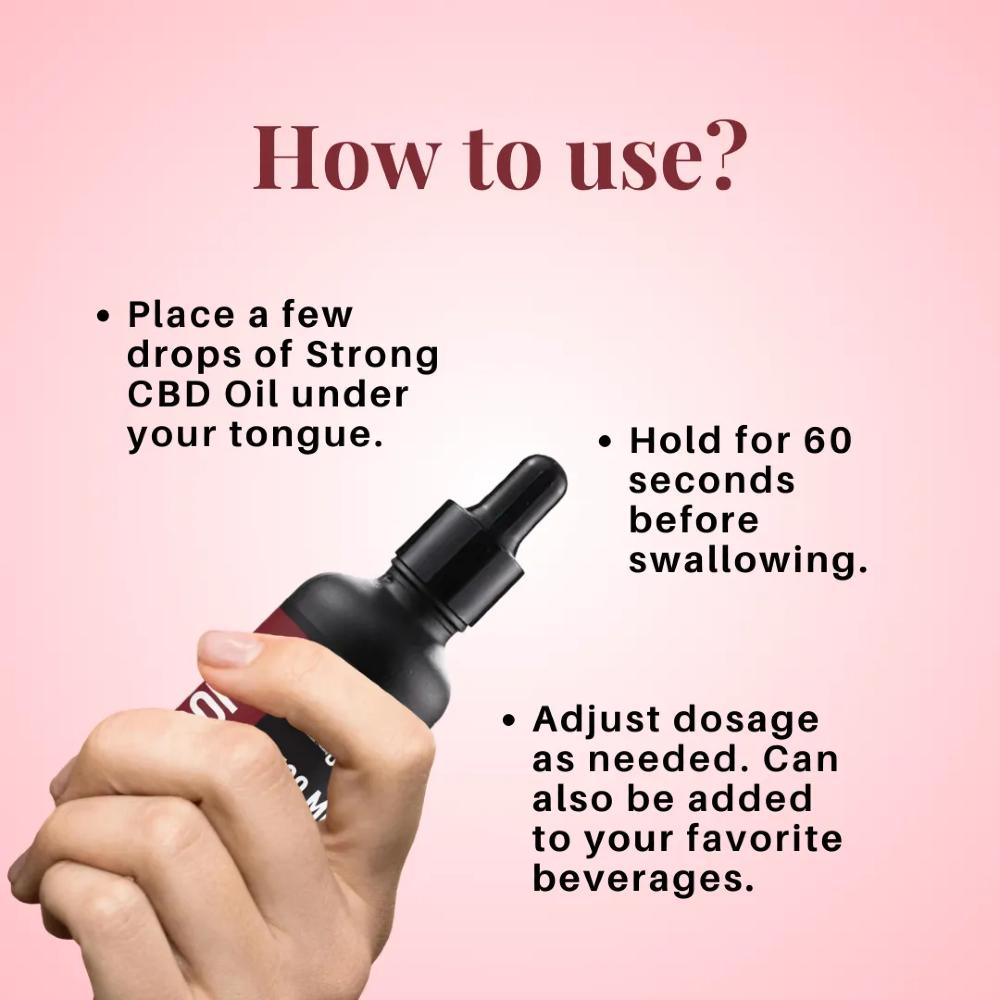 Hand holding a dropper with instructions on using Cure By Design Strong CBD Oil on a pink background