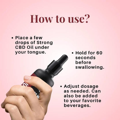 Hand holding a dropper with instructions on using Cure By Design Strong CBD Oil on a pink background