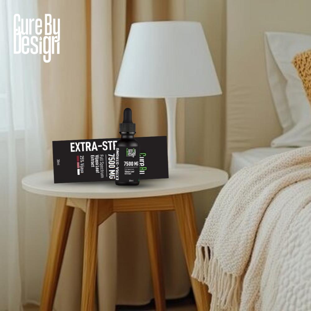 Nightstand with 'Cure By Design' products including a box labelled 'EXTRA-STRONG' and a dropper bottle, next to a bed with beige bedding.