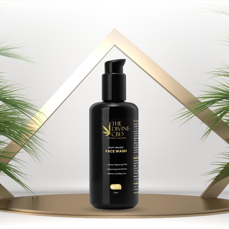 Black bottle of "The Divine CBD" face wash with pump dispenser on a golden platform.