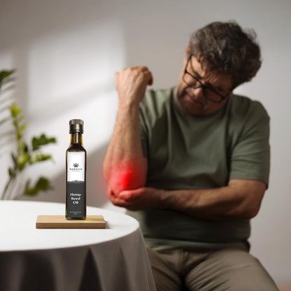 Man with a bottle of hemp seed oil on a table