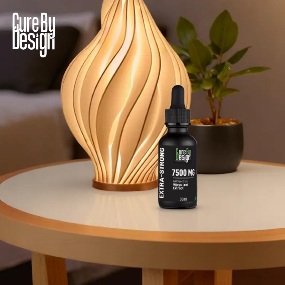 Bottle of 'Cure By Design' CBD Oil product on a table with decorative lamp and plant in the background