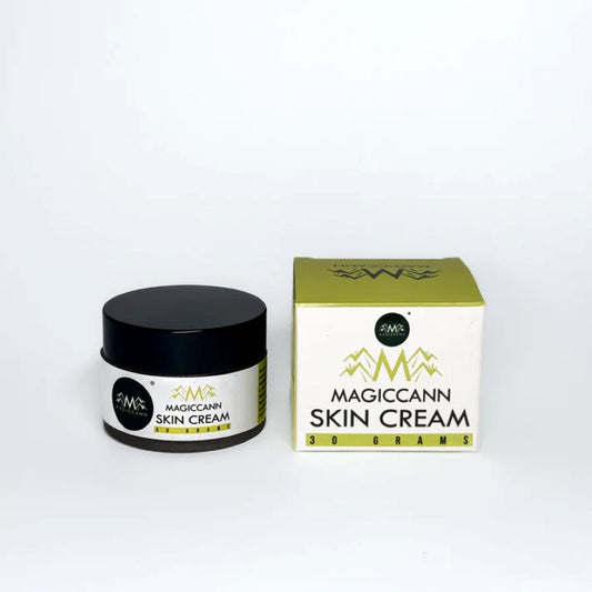 A jar and box of "MAGICCANN HEMP SKIN CREAM" with a green mountain design.


