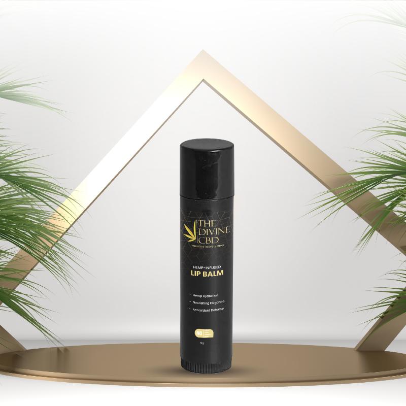 Black cylindrical lip balm tube with gold text, centered against a white background with golden triangles and green palm leaves.

