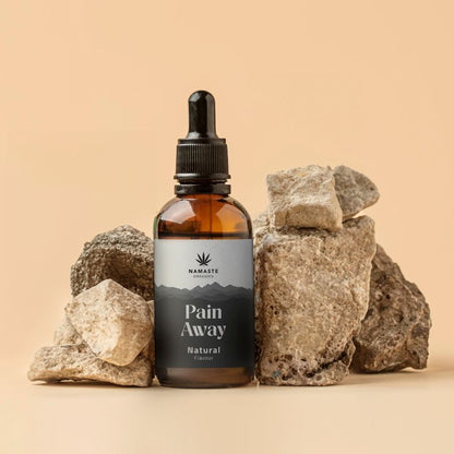 Bottle of 'Pain Away'  Full spectrum CBD Oil product with rocks on a beige background