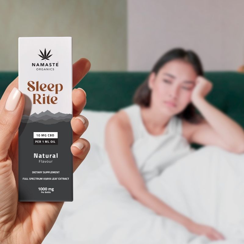 Hand holding a 'Sleep Rite'  Full spectrum CBD Oil supplement package with a blurred background of a person on a bed.