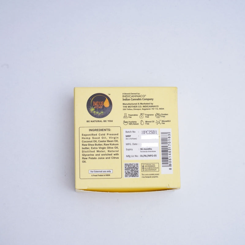 Back of a yellow product packaging with text and a logo on a light gray background