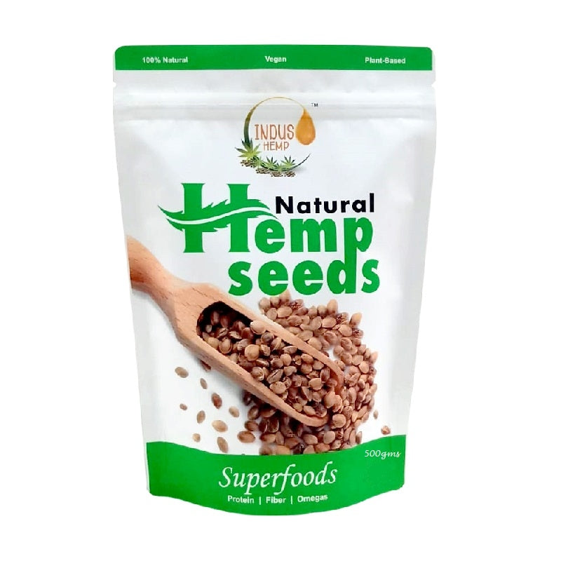 Bag of natural hemp seeds with a wooden spoon on a white background