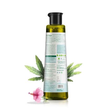 Bottle of Hemp shampoo with a label and green leaves on a white background