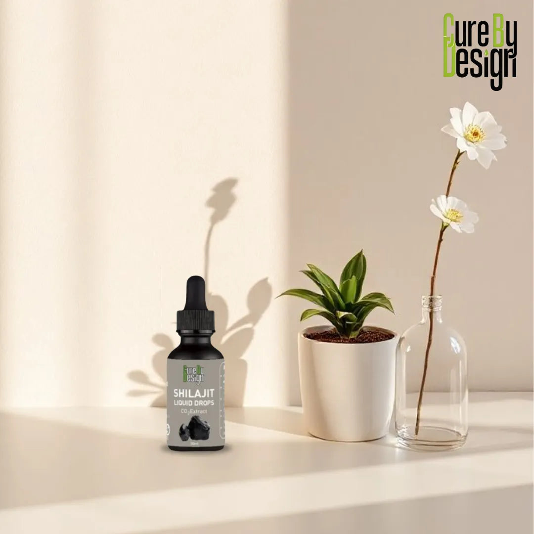 Shilajit liquid drops bottle with a plant and flower on a neutral background, featuring 'Cure by Design' branding.