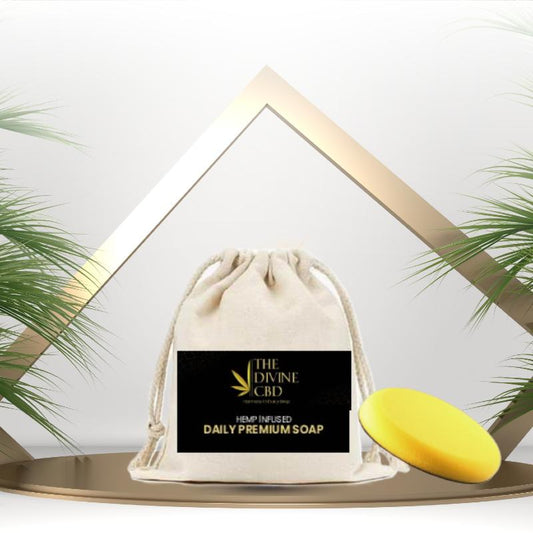 Beige drawstring bag with a label, and a yellow soap on a flat surface, flanked by green plants.


