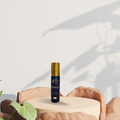 Bottle of Paarmi Cares product on a round pedestal with rocks and a plant.