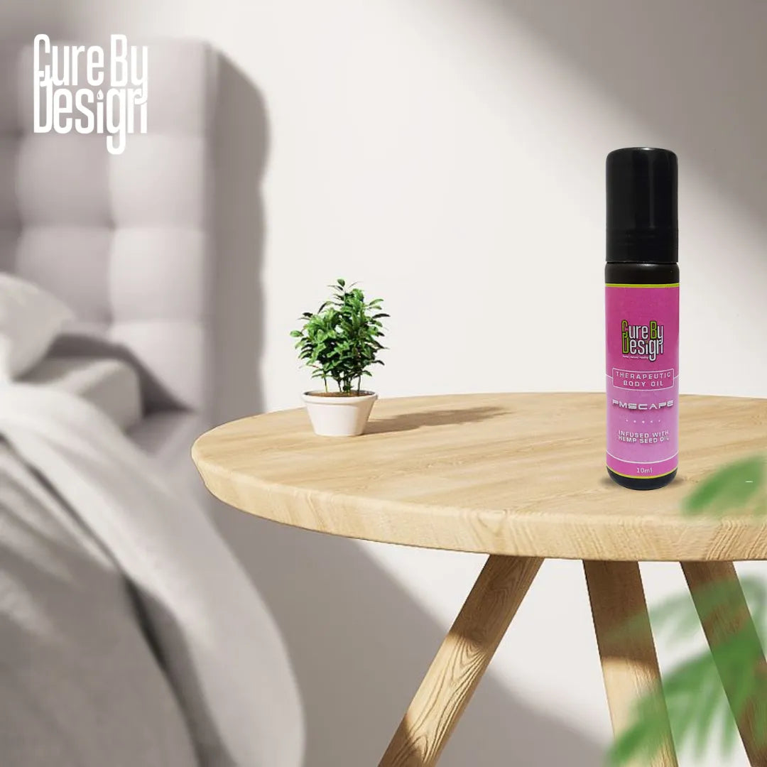 Purple bottle with black cap on a wooden table next to a small potted plant, with 'Cure By Design' branding.
