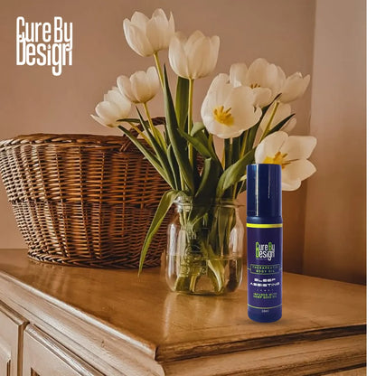 Cure By Design product on a wooden surface with white tulips in the background