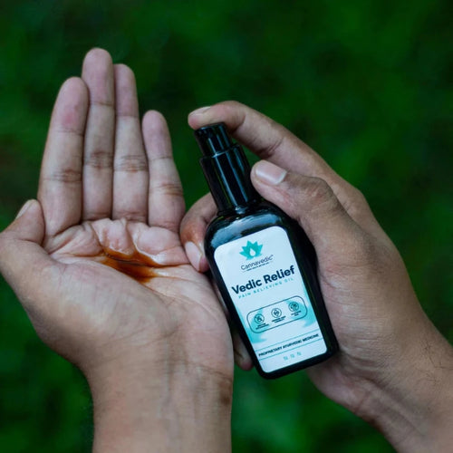  Hands applying CannaVedic Relief pain relieving oil.