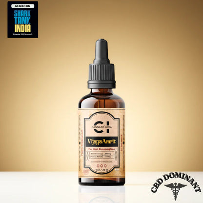 An amber glass dropper bottle of Cannazo Vijaya Amrit CBD tincture, set against a warm beige gradient background. The bottle has a black dropper cap and a beige label with black and gold text.
