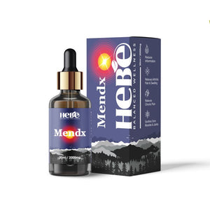 CBD oil bottle with a gold cap in front of its blue and black packaging box featuring mountain graphics and the brand 