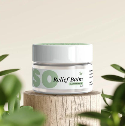 Jar of "INTENSO CBD Relief Balm" on a wooden surface with green leaves in the background.
